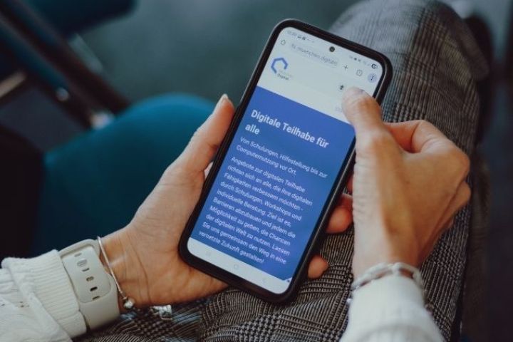 Die Teilnehmenden schauen sich die neue Angebotsplattform auf ihrem Handy an.