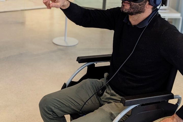 Der VR-Rollstuhlsimulator besteht aus einem Rollstuhl, einem kabellosen VR-Headset und VR-Trackern, die die Bewegung der Reifen erfassen, um die Interaktion zwischen Rollstuhlfahrerinnen und anderen Verkehrsteilnehmenden zu untersuchen.