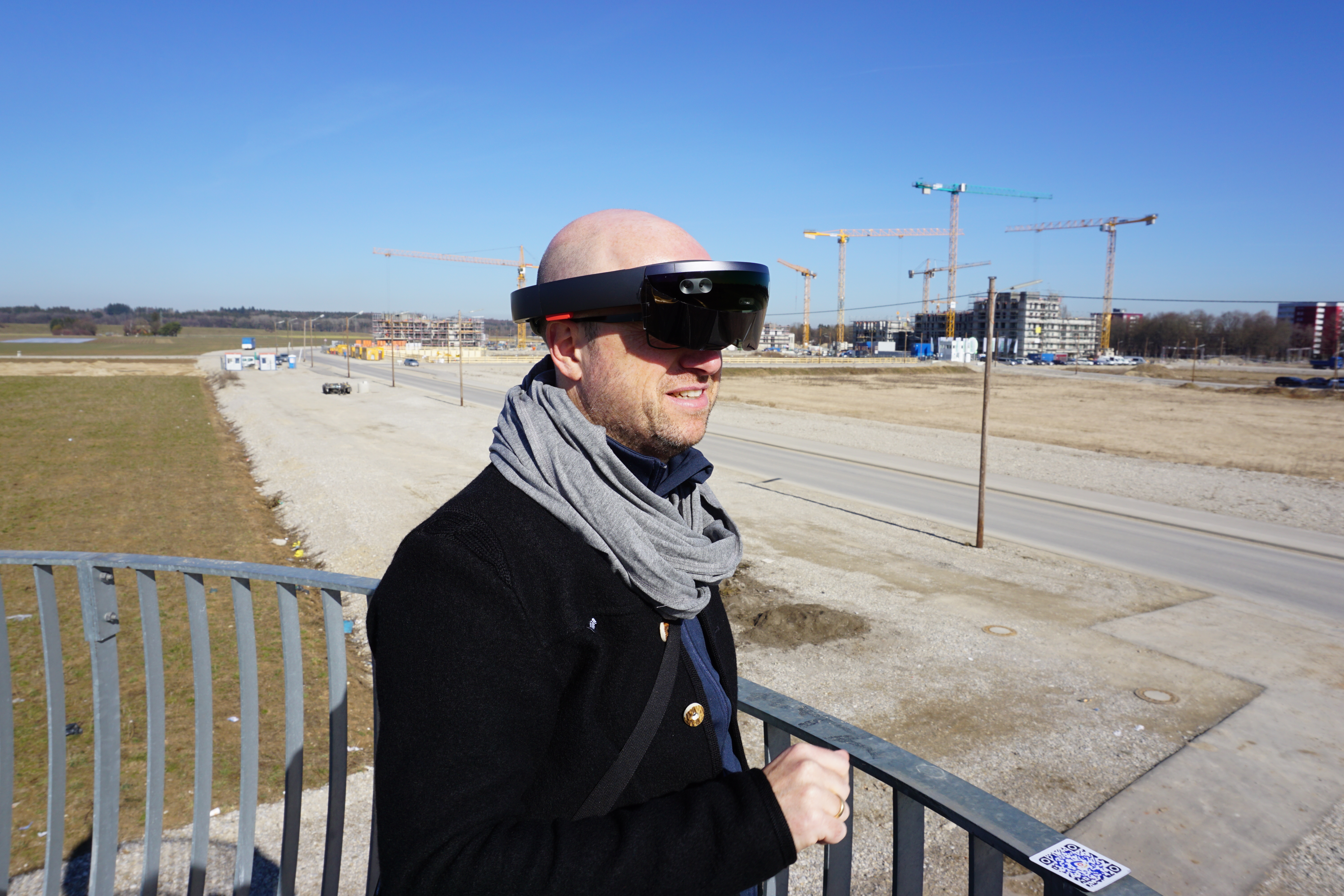 Markus Mohl, GeodatenService München, bei der Verwendung einer AR-Brille zur Visualisierung der maximalen, geplanten Bauvolumina vor Ort in Freiham.