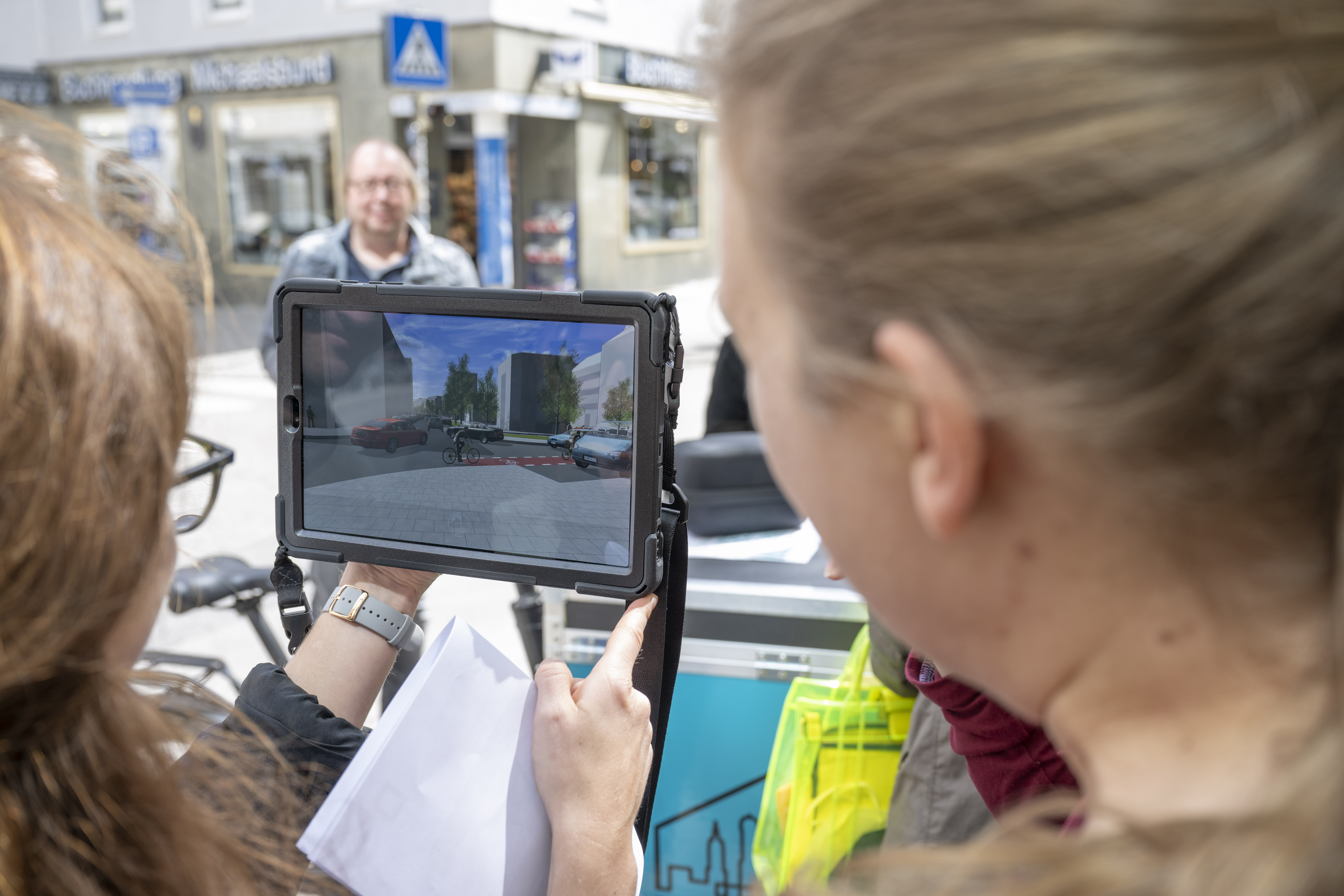 Foto von zwei Personen, die ein Tablet mit der 3D Szene des Freiraumquartierskonzept Innenstadt Fokusraum 